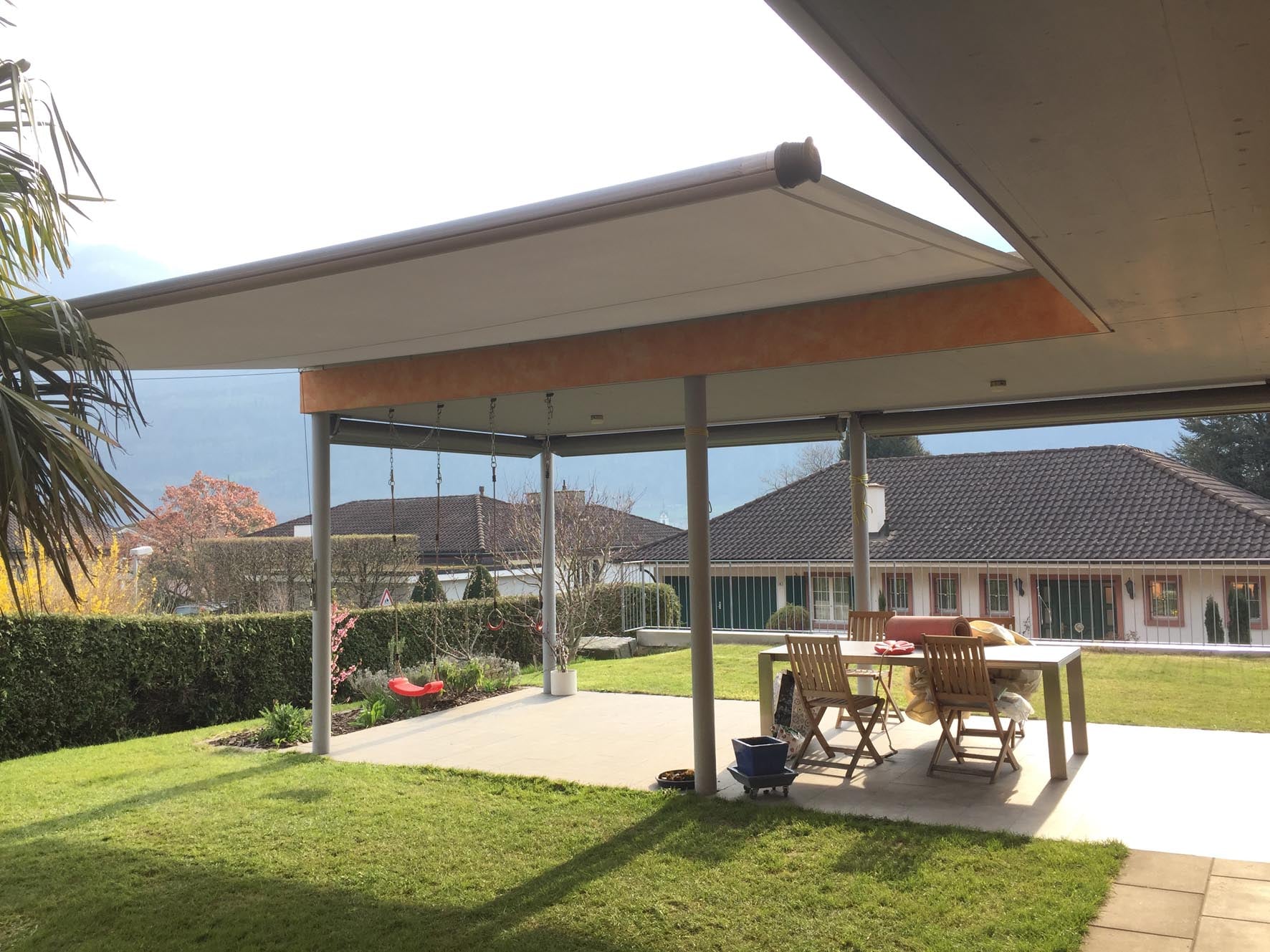 Überdachte Terrasse mit grosser Beschattungsanlage, Gartenmöbeln und Rasen